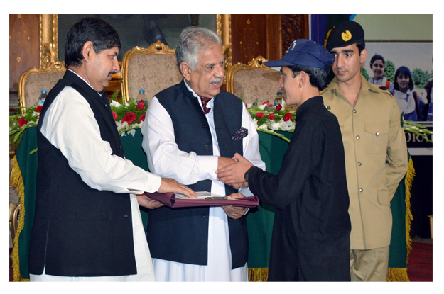 Governor Iqbal Zafar Jhagra awarding certificate to FATA position holder student during the ceremony. PHOTO: INP