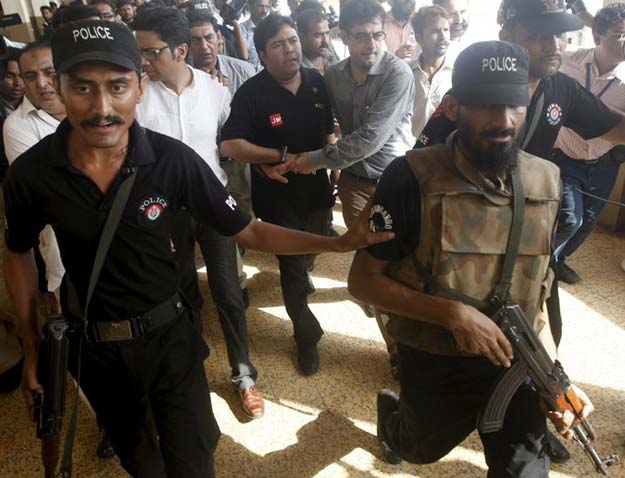 Shoaib Ahmed Shaikh, center, the chief executive of Axact, was escorted from a court appearance last May. PHOTO: REUTERS