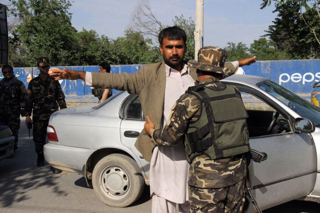 Afghan security personnel search commuters at a checkpoint in Kunduz province on April 15, 2016. PHOTO: AFP