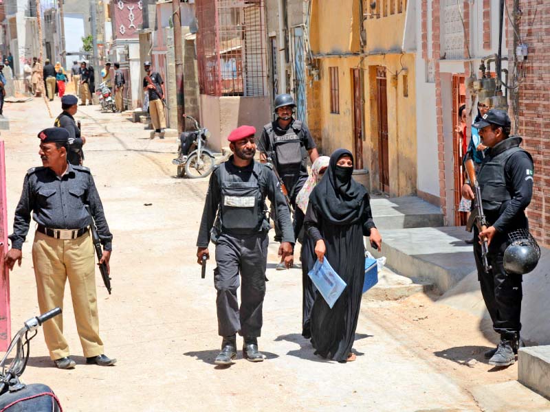 Policemen continued to provide security to health workers on the last day of the polio campaign on Thursday despite Wednesday’s brutal attack. PHOTO: MOHAMMAD AZEEM/EXPRESS