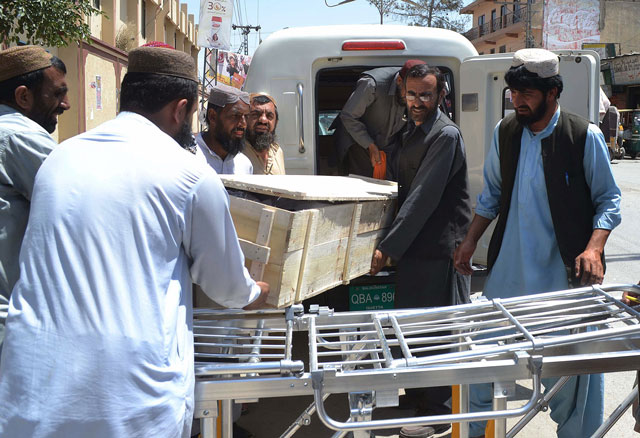 Security officials and hospital staff move a dead body into a morgue in Quetta on May 22, 2016. PHOTO: AFP