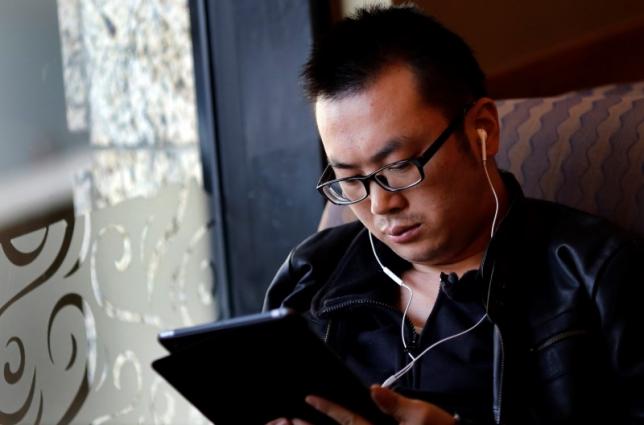 A man use his iPad inside a local coffee shop in downtown Shanghai November 28, 2013. PHOTO: REUTERS