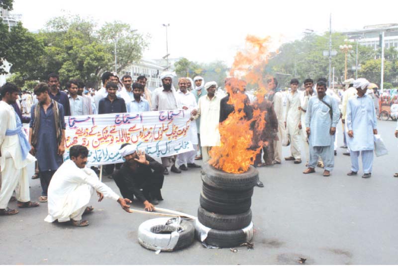 PKI activists set fire to tyres on The Mall. PHOTO: ABID NAWAZ/EXPRESS