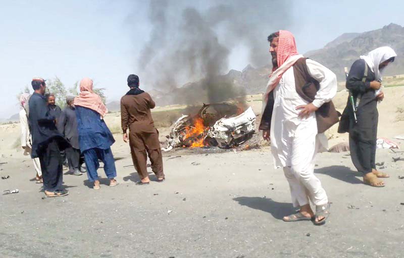 People gather around a destroyed vehicle in which Mullah Akhtar Mansour was travelling on May 21, 2016. PHOTO: AFP