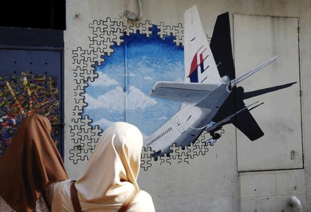 Women look at a mural of missing Malaysia Airlines flight MH370 two years after it disappeared, in Kuala Lumpur, Malaysia, March 7, 2016.
PHOTO: REUTERS