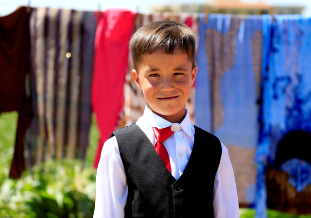 A Syrian boy living in the refugee camp of Delhemiyeh village, poses in new clothes as he celebrates Eidul Fitr, July 6, 2016. PHOTO: REUTERS/Jamal Saidi