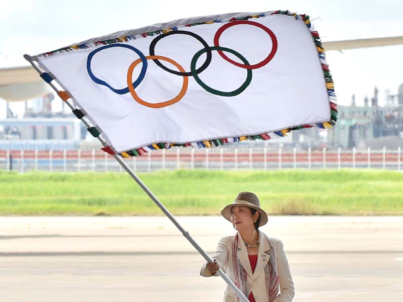 Tokyo governor Yuriko Koike carried the flag during a ceremony at Haneda airport after stepping off a plane from the Brazilian host city, accompanied by a delegation who picked up a record 41 medals in Rio. PHOTO: AFP