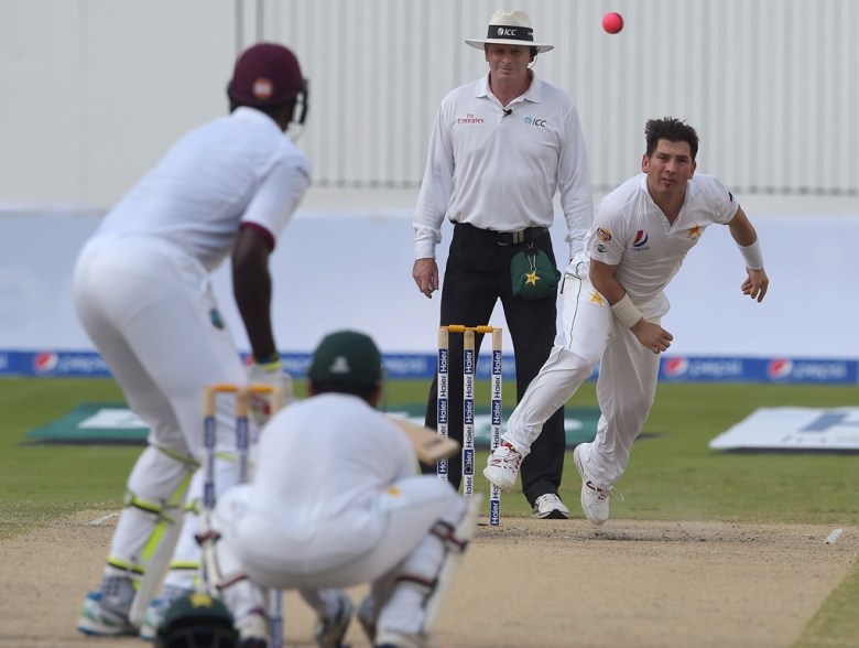 Yasir Shah (R) delivers the ball on the fourth day of first day-night Test on October 16, 2016. PHOTO: AFP