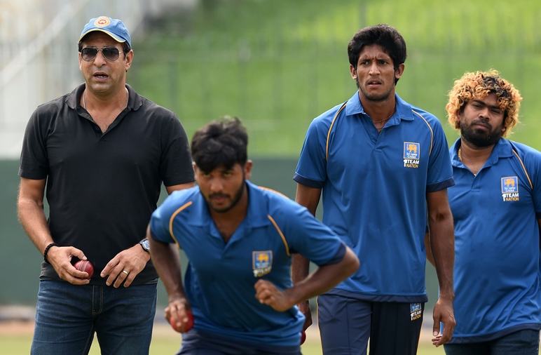 Sri Lankan cricketers Lasith Malinga (R) and Kasun Rajitha (2R) look on during the first coaching session by former Pakistan cricketer Wasim Akram (L) at the Sinhalese Sports Club (SSC) grounds in Colombo on December 1, 2016. 
PHOTO: AFP
