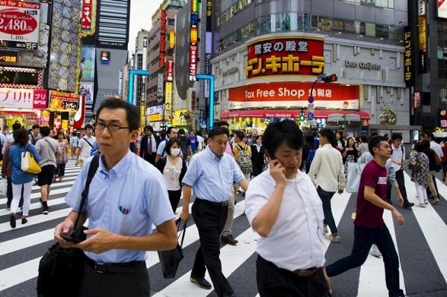 People cross a busy junction outside the nightlife district in Shinjuku in Tokyo. PHOTO: REUTERS