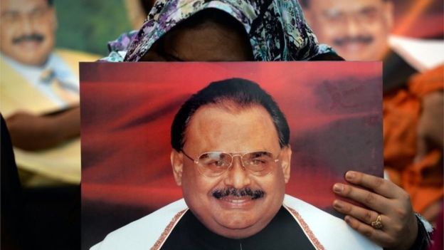 MQM supporters hold pictures of party chief Altaf Hussain. PHOTO: REUTERS