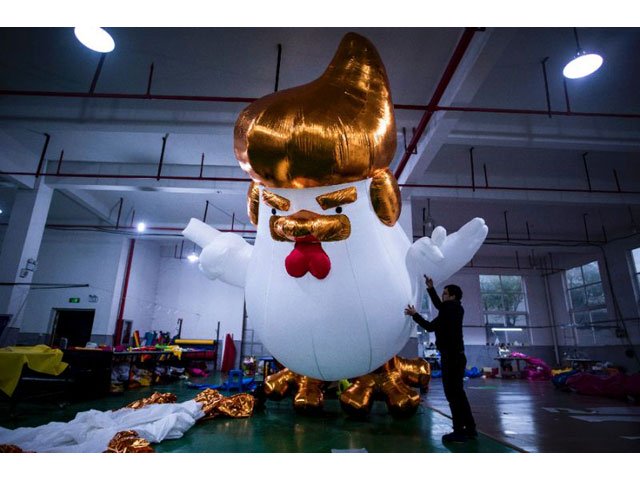 A golden mane and tiny wings that mimic his hand gestures -- the resemblance of inflatable chickens produced for the Chinese New Year to US President-elect is unmistakable. PHOTO: AFP