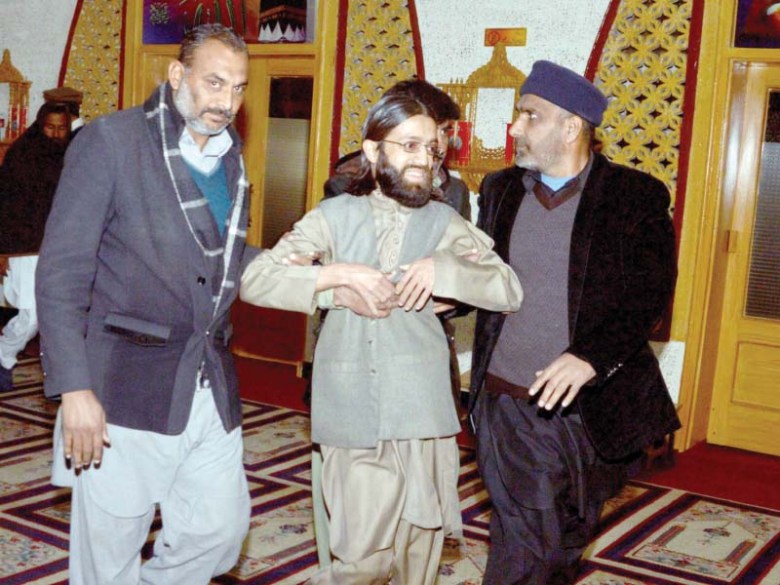 Security officials haul away Shuhada Foundation Spokesman Ihtisham Ahmed. PHOTO/MUDASSAR RAJA/EXPRESS