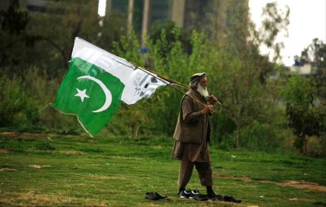 A supporter of the Jamaat-ud-Dawa Islamic organization holds a Pakistani national flag 
PHOTO: FAISAL MAHMOOD / REUTERS