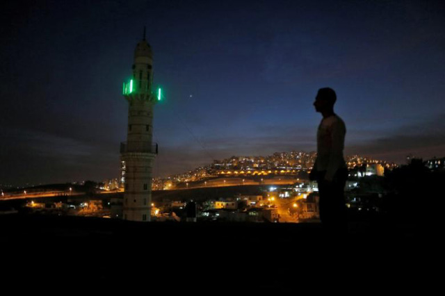 A man stands near a mosque opposite to a neighborhood in east Jerusalem. PHOTO: REUTERS