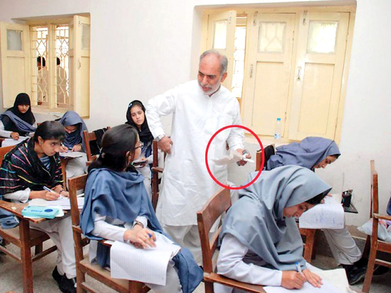 In the file photo above, Board of Education, Sukkur, examination controller Mehmoodul Hasan Khokar is seen confiscating cheating material from students. PHOTO: FILE