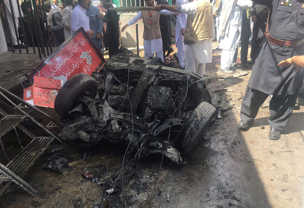Security officials and residents gather at the site of a powerful explosion at a market in Parachinar, capital of the Kurram tribal district, on March 31, 2017. PHOTO: AFP