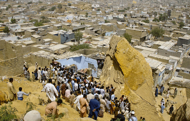 The ill-fated house situated on a hill in Gulshan-e-Ghazi of the area was hit by a boulder at around 4am when the family was sleeping inside, said Baldia Town SP Asif Razzak. PHOTO: INP