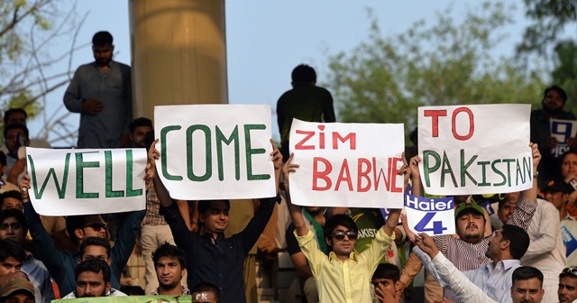Pakistani spectators carry placards as they await the start of the first International T20 cricket match between Pakistan and Zimbabwe at the Gaddafi Cricket Stadium in Lahore on May 22, 2015. PHOTO: AFP