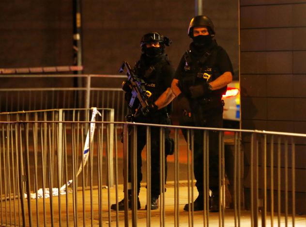 Armed police officers stand next to a police cordon outside the Manchester Arena, where U.S. singer Ariana Grande had been performing. PHOTO: REUTERS