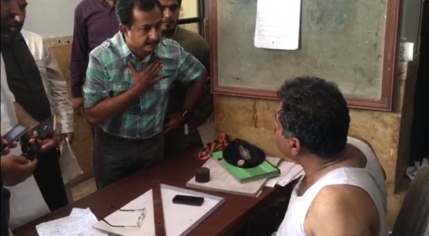 PTI leader negotiates with the SITE SHO for his arrested party activists' release. PHOTO: Screengrab