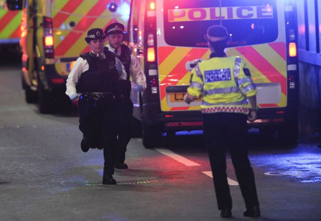 Police officers run at the scene of an apparent terror attack on London Bridge in central London on June 3, 2017. PHOTO: AFP
