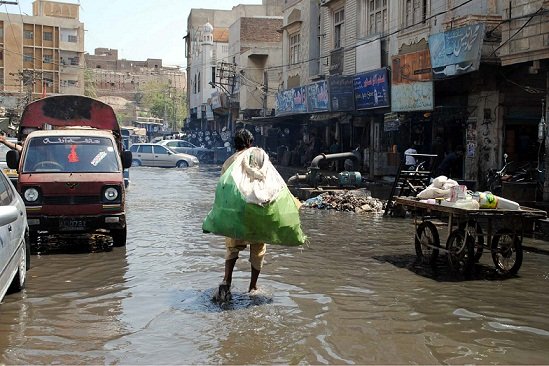 A dismal situation: Commuters pass through stagnant sewerage water, which created an unhygienic atmosphere and shows the negligence of the concerned authorities in Hyderabad. PHOTO: FILE