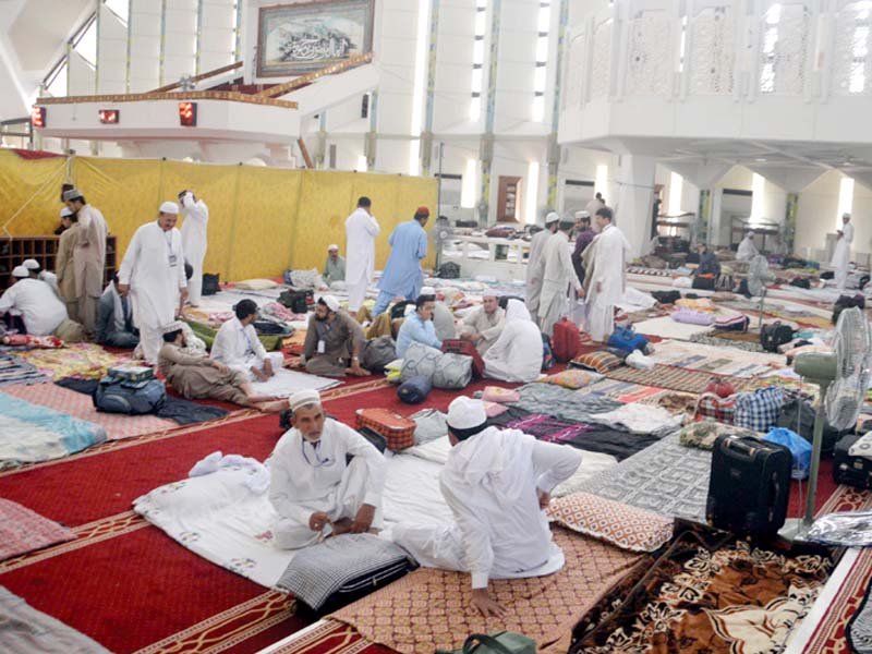 People come to attend the Aitekaf in Faisal Mosque, while security officials check their luggage. PHOTO: MUDASSIR RAJA/EXPRESS