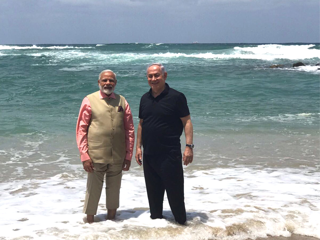 Israel's PM Benjamin Netanyahu walks with India's PM Narendra Modi, as they visit Olga Beach near Hadera, Israel on Thursday. PHOTO: TWITTER