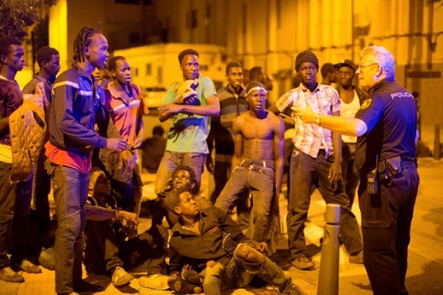 African migrants listen to a police officer after crossing the border from Morocco to Spain's North African enclave of Ceuta, Spain, early August 1, 2017. PHOTO: REUTERS