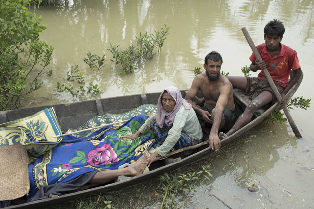 This file photo taken on September 6, 2017 shows the bodies of Rohingya refugees being brought to the shore of the Naf river on a boat by fellow Rohingyas in Ukhiya. PHOTO: AFP