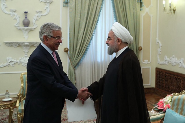 Foreign Minister Khawaja Asif shakes hands with Iranian President Hassan Rowhani. PHOTO: PID