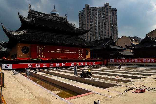 This file picture taken on September 5, 2017 shows construction personnel working to relocate the main hall of the 135-year old Yufo Temple, also known as the Jade Buddha Temple, in Shanghai. The main hall and statues of the temple in central Shanghai have been moved 30 metres (100 feet) on rails to ease crowding at the popular site. PHOTO: AFP