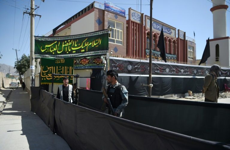 An Afghan policeman stands guard outside of the Baqir ul-Uloom mosque ahead of Ashura in Kabul. PHOTO: AFP