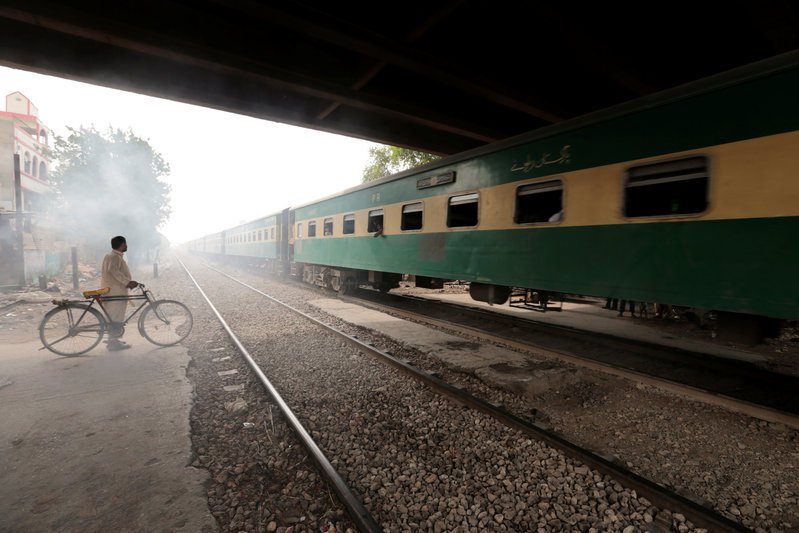 A man waits to cross a portion of track once shared with the disused Karachi Circular Railway line in Karachi, Pakistan, May 24, 2017. PHOTO: REUTERS