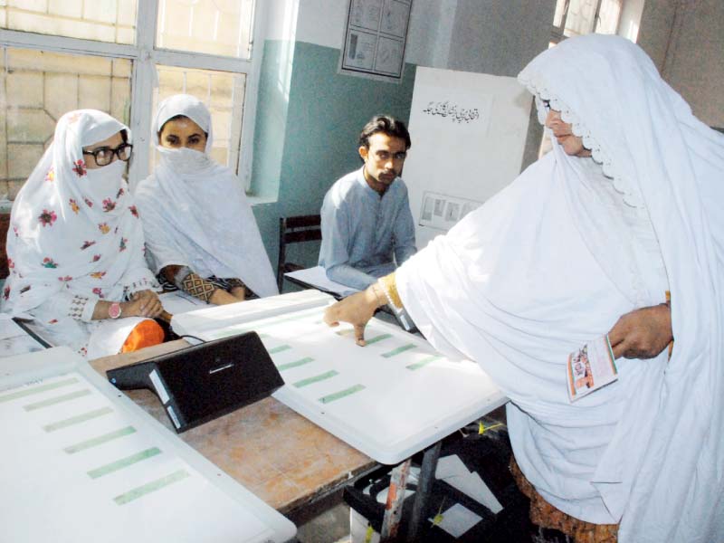 A woman uses an electronic voting machine. PHOTO: IQBAL HAIDER/EXPRESS