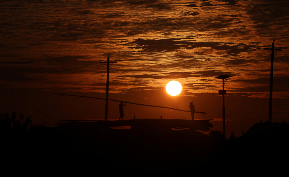 Rohingya refugees unload bamboo from a truck during sunset in the Kutupalong refugee camp near Cox's Bazar, Bangladesh. PHOTO: REUTERS