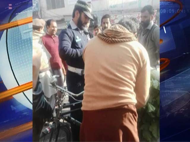 A traffic cop issuing Rs200 challan to a bicycle-rider in Peshawar. PHOTO: EXPRESS/SCREENGRAB