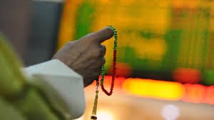 An investor holds the tasbeeh as he monitors electronic boards displaying stock information
PHOTO:REUTERS