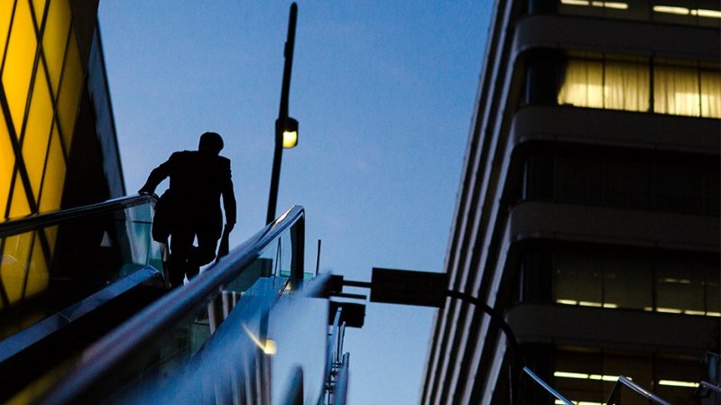 A businessman rides an escalator at a banking district. PHOTO: REUTERS