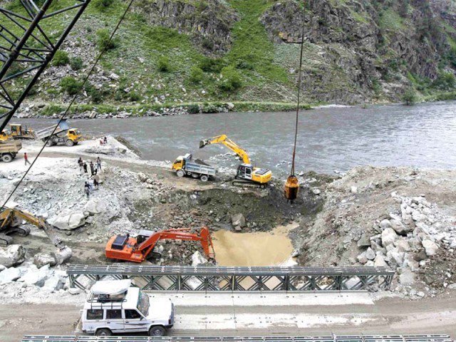 A private vehicle crosses a bridge as excavators are used at the dam site of Kishanganga power project in Gurez, 160 km north of Srinagar. PHOTO: REUTERS