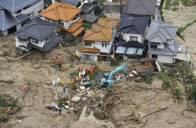 Rescue workers are seen next to houses damaged by a landslide following heavy rain in Hiroshima, western Japan, in this photo taken by Kyodo July 7, 2018. PHOTO: REUTERS