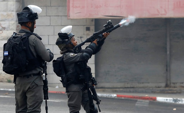 An Israeli border policewoman fires a tear gas canister towards Palestinians during clashes in the village of Khobar near Ramallah, in the occupied West Bank July 27, 2018. PHOTO: REUTERS