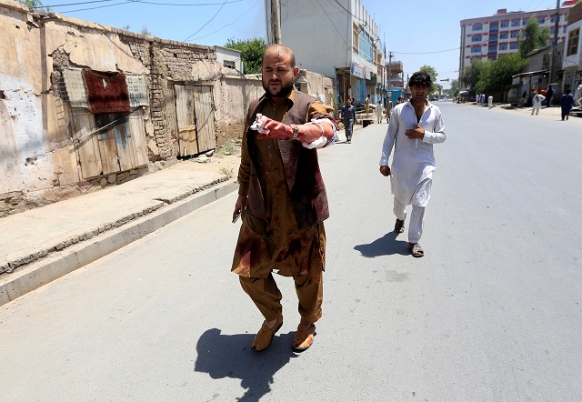 An injured man leaves the area where explosions and gunshots were heard, in Jalalabad city, Afghanistan July 31, 2018. PHOTO: AFP