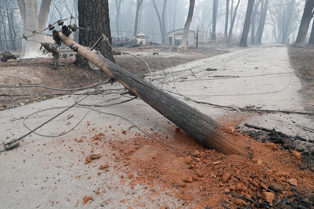 Damaged power pole following the deadly Camp Fire blocks a path in Paradise, California, US, November 13, 2018. PHOTO: REUTERS