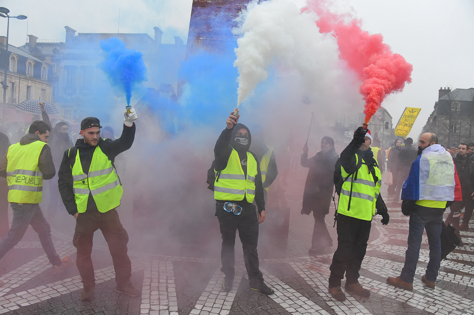 Protestors light flares in the colours of the French flag during a "Yellow Vest" (Gilets jaunes) anti-government protest on December 22, 2018, in Bordeaux, southwestern France, as part of a nationwide day of demonstrations. PHOTO: AFP