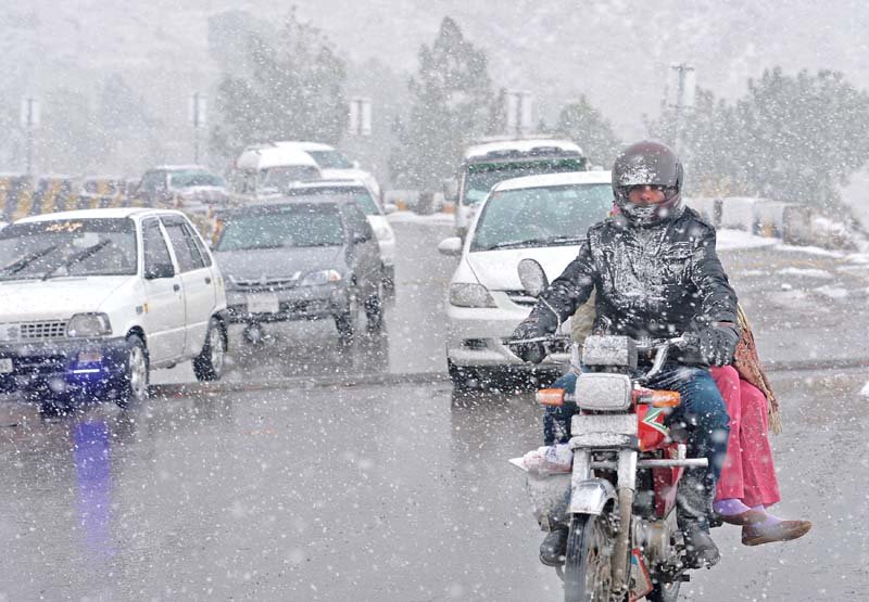People head to Murree in cars and even on motorcycle for enjoying snowfall. PHOTO: AFP