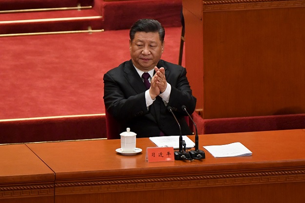China's President Xi Jinping applauds during a celebration meeting marking the 40th anniversary of China's reform