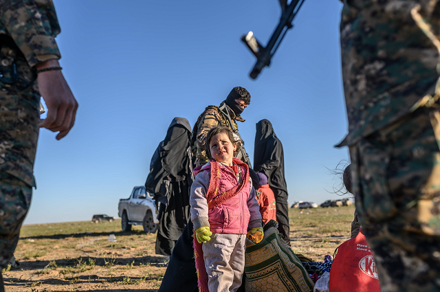 A toddler looks at members of the Kurdish-led Syrian Democratic Forces (SDF) while awaiting to be searched, after leaving the Islamic State (IS) group's last holdout of Baghouz, in the eastern Syrian Deir Ezzor province on March 1, 2019. PHOTO: AFP