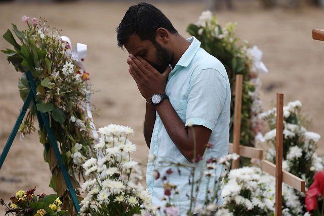 A man reacts during mass burials near St. Sebastian church in Negombo. PHOTO: REUTERS